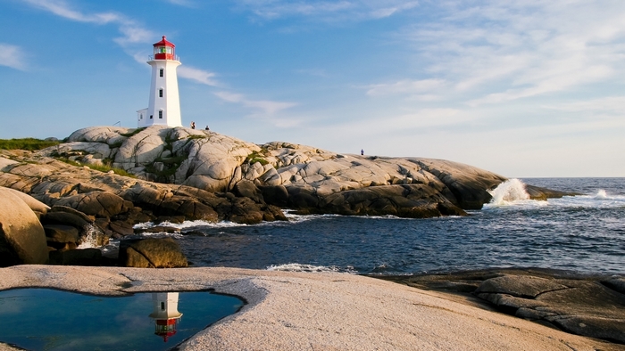 White lighthouse on rocky coast with ocean waves
