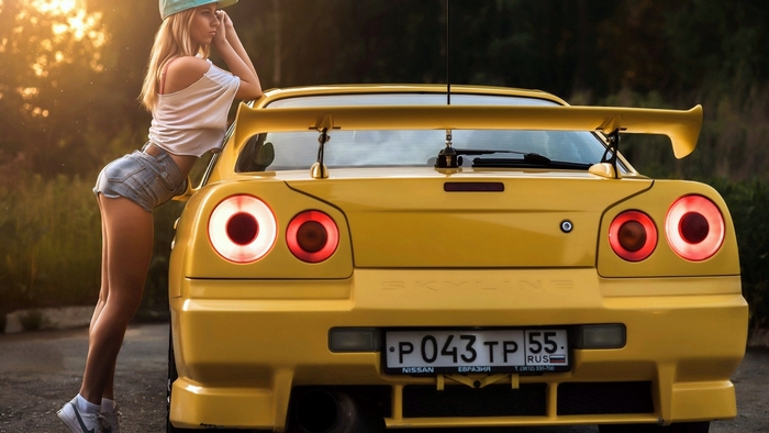 Yellow Nissan Skyline with Blonde Model in Shorts