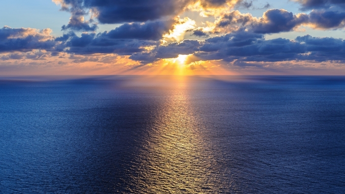 Sunset over the ocean with clouds