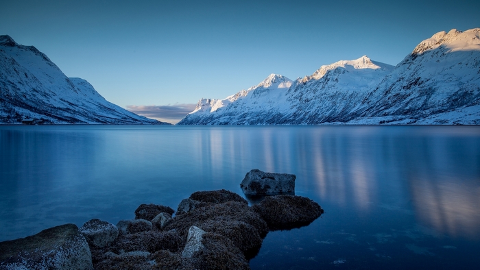 Snowy mountains reflecting in a calm lake