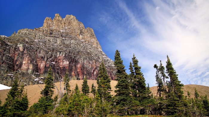 Mountain peak with pine trees and blue sky