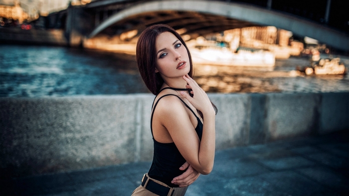 Brunette model posing near a bridge