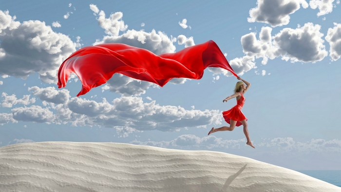 Woman Running on Sand Dune with Flowing Red Fabric