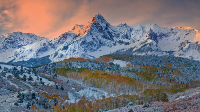 Snow-covered mountains with autumn trees