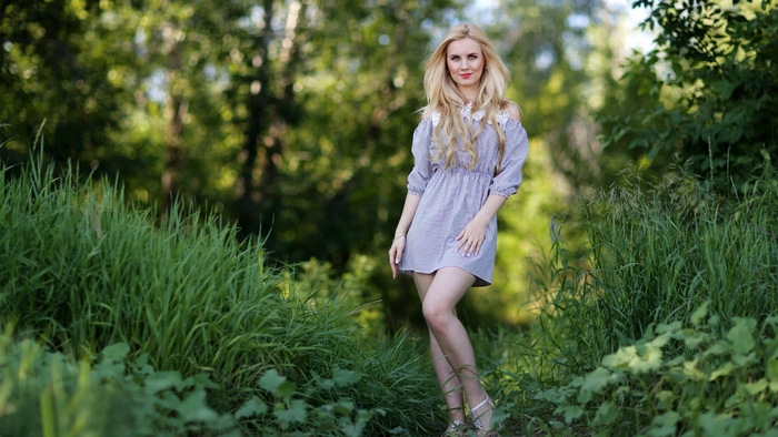 Blonde woman in a dress in a forest