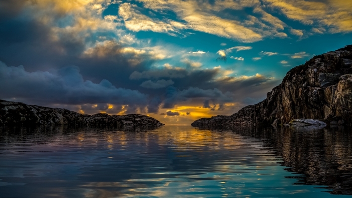 Sunset Over Rocky Sea Coast with Cloudy Sky