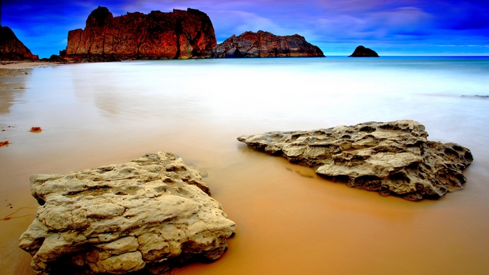 Beach with rocks and sea at sunset
