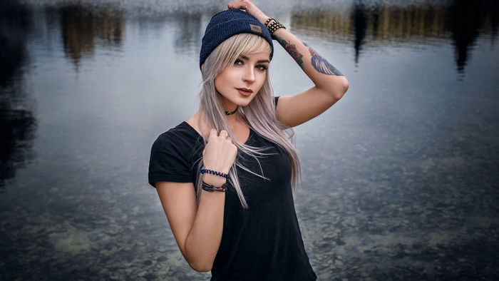 Woman with blonde hair and tattoos wearing a beanie