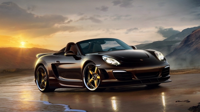 Brown Porsche Boxster convertible on a beach at sunset