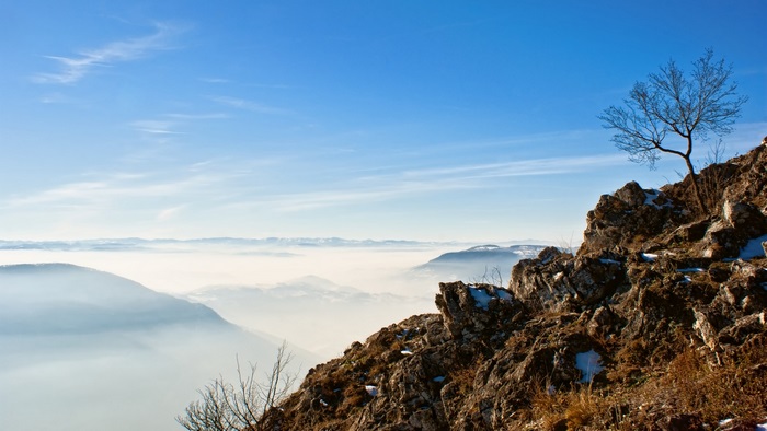 Mountain view over a foggy valley under blue skies