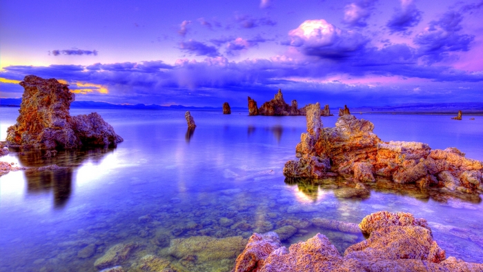 Tranquil Sea with Rocky Formations under Cloudy Sky