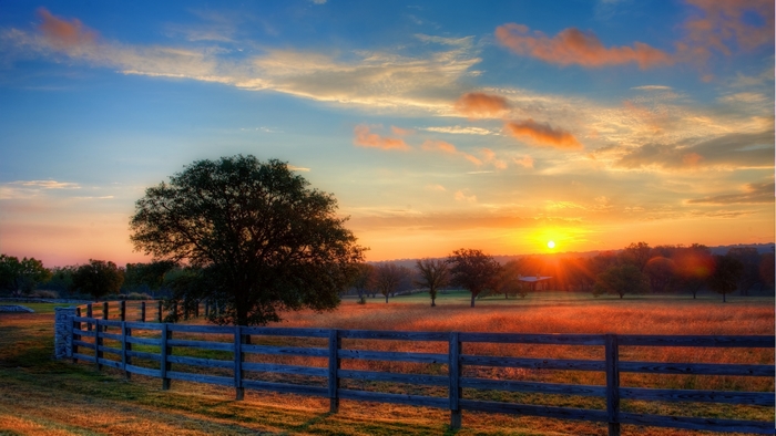 Rural landscape at sunrise with wooden fence