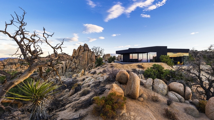 Modern black house in a rocky desert landscape