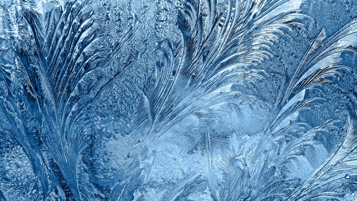 Close-up of frost patterns on a blue surface