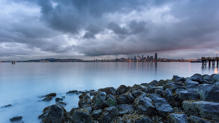 Seattle skyline across the water with a pier