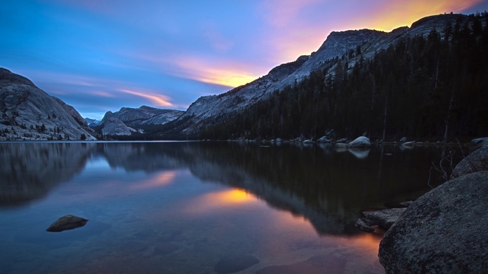 Lake reflection at sunset with mountains and trees