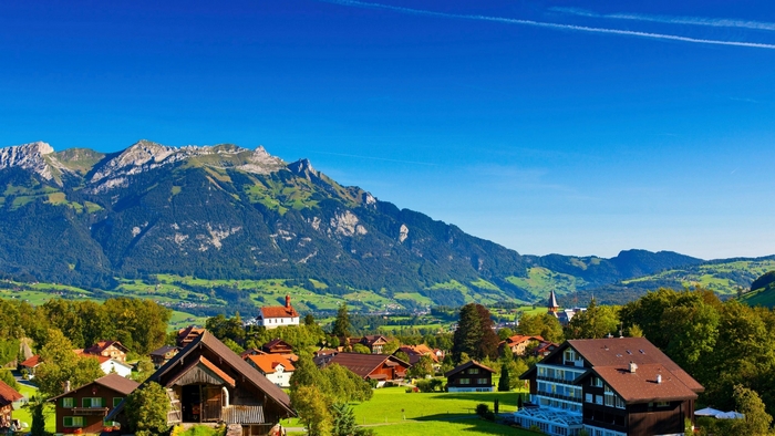 Alpine village with mountains and blue sky