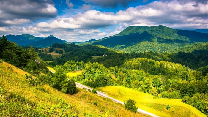 Rolling green hills and mountains with a road