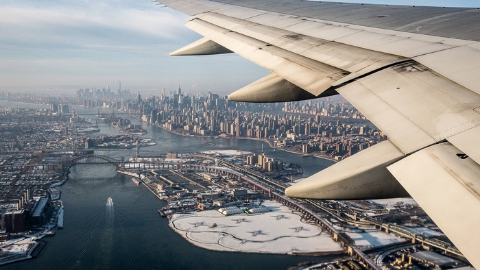 Airplane wing over New York City skyline