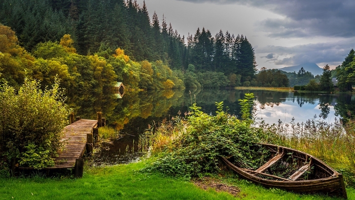 Abandoned boat by a lake with reflections