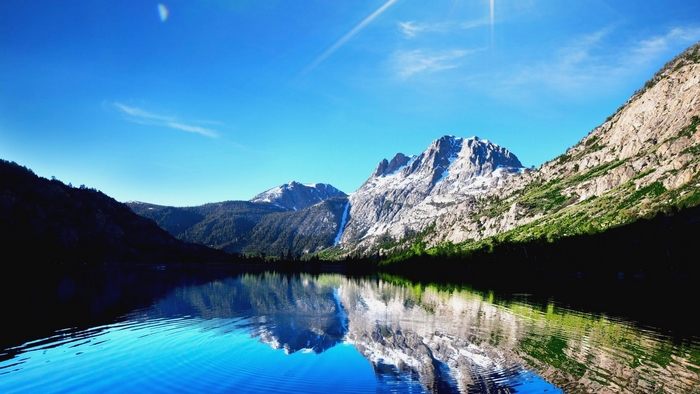 Mountain lake reflection under a clear blue sky