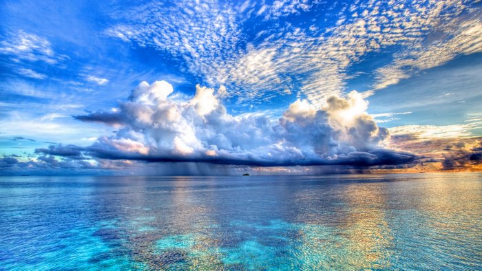 Dramatic clouds over a tropical ocean with a distant island