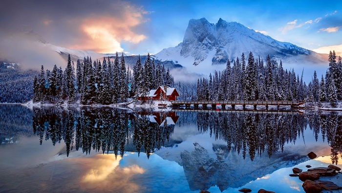 Snowy forest and mountains reflected in a lake