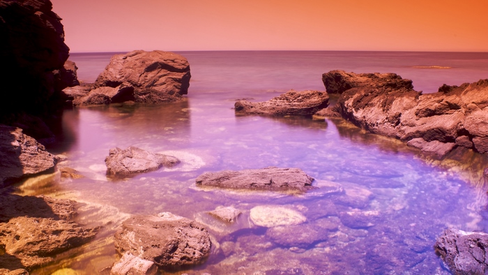 Rocky shore with calm water at dusk