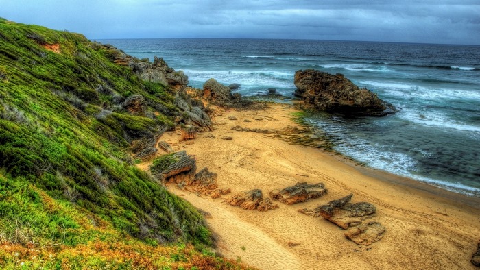 Stormy Beach with Rocks and Green Grass