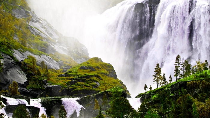 Majestic waterfall cascading down a rocky, moss-covered mountain
