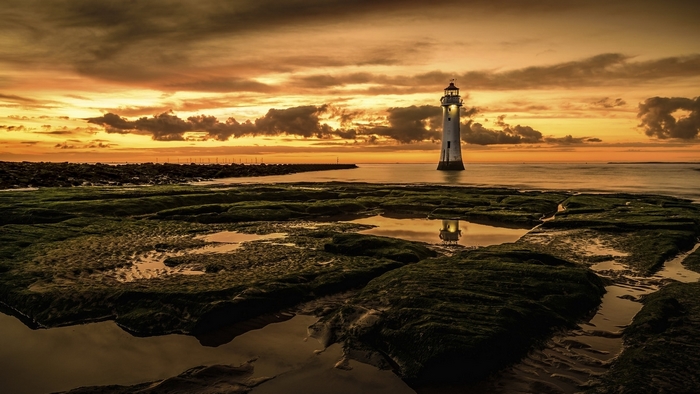 Lighthouse on the sea at sunset
