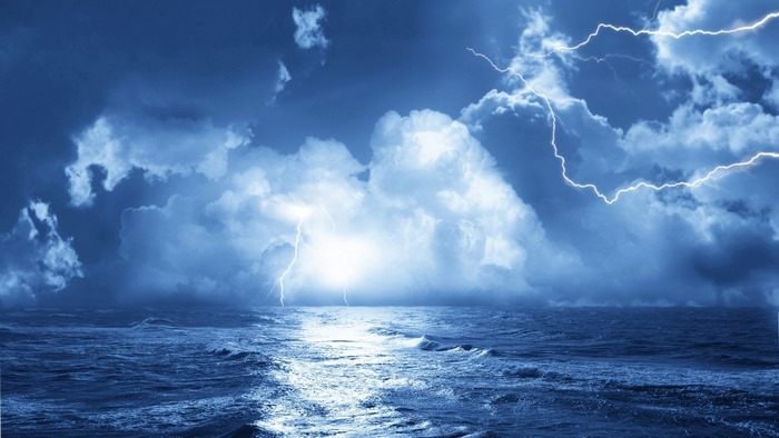 Lightning strikes over a stormy ocean with dark clouds