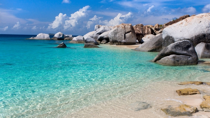 Tropical beach with clear turquoise water and large boulders