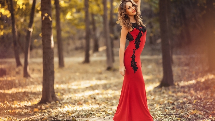Woman in red dress in autumn forest