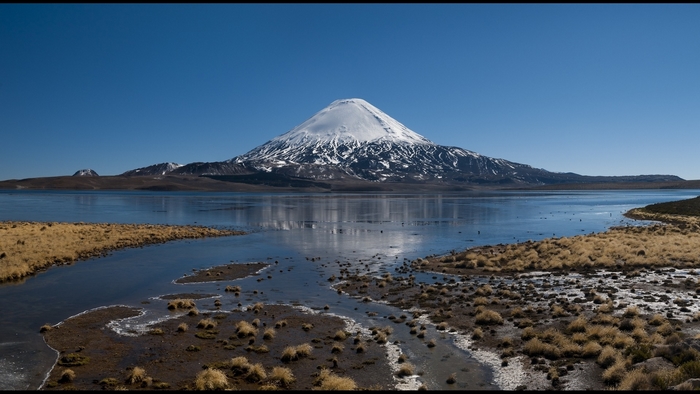 Snowy Volcano Overlooking a Lake in Chile