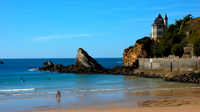 Beach with castle on cliff overlooking the ocean