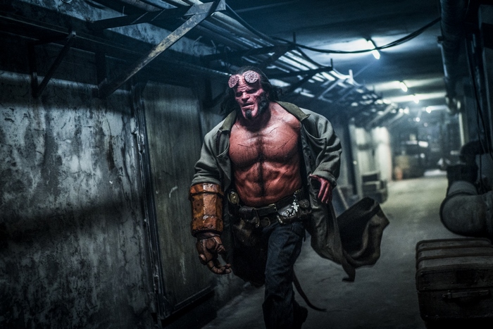 Hellboy running in a dark corridor