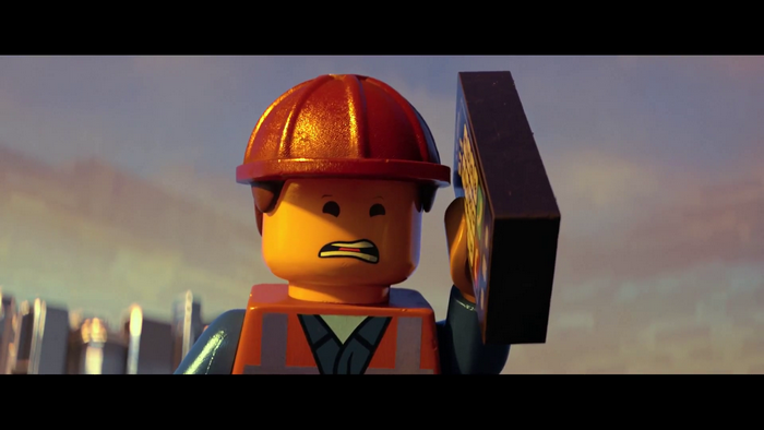 Emmet from The Lego Movie holding a Lego brick
