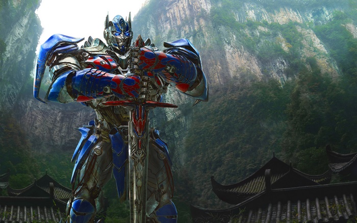 Optimus Prime holding a sword in a mountainous landscape