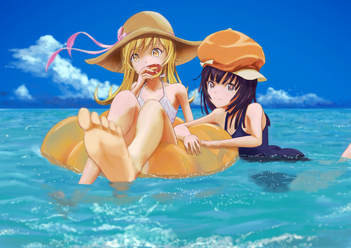 Two girls in swimsuits on an inflatable in the ocean