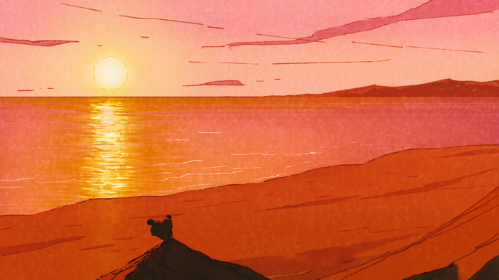 Sunset over the ocean with a person on a rock