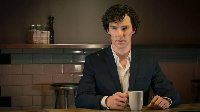 Sherlock Holmes holding a mug