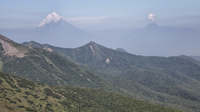 Volcanoes erupting in a mountainous landscape