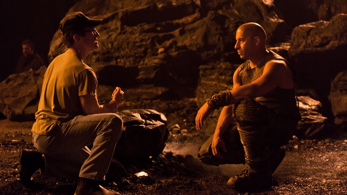 Riddick and another man in a cave