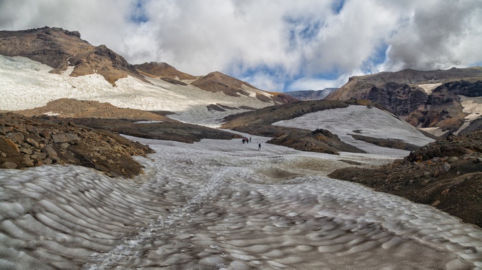 Hikers on a snow-covered mountain slope