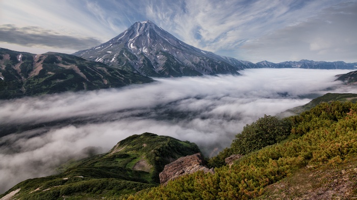 Volcano above clouds in a mountain range