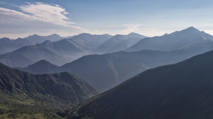 Layered mountain ranges under a hazy sky