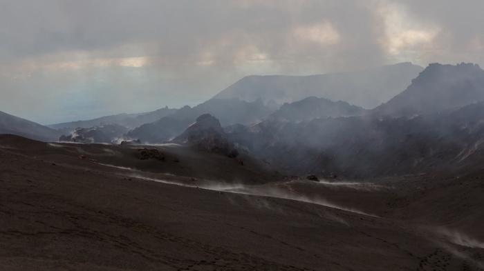 Volcanic landscape with smoke and dust