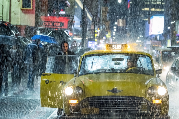 John Wick exiting a taxi in the rain