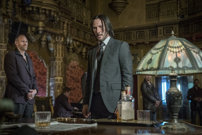 John Wick in a dimly lit room with a piano player